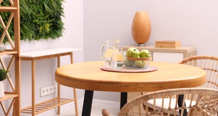 Wooden table with chairs and decor in stylish dining room. Interior design
