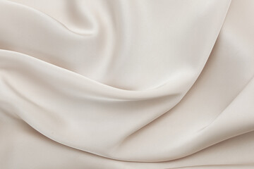 Soft beige fabric draping elegantly on a neutral background for design inspiration
