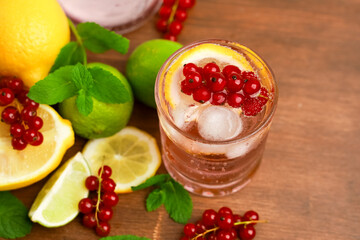 Refreshing berry drink with citrus fruits and mint on a wooden surface in a summer setting