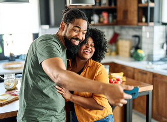 Portrait of a young happy couple having fun taking a selfie with camera on smartphone in kitchen at home. Girlfriend and boyfriend bonding, preparing food lunch or dinner,  love concept
