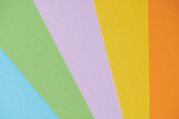 Various colorful sheets of paper are displayed in a fan shape, showcasing vibrant hues.