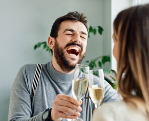 Portrait of a handsome man having fun drinking and toasting with his girlfriend or friend