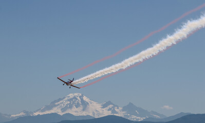 A smoke airplane with a mountain in the background	