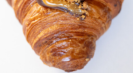 Delicious golden-brown croissant adorned with chocolate and caramel drizzle.