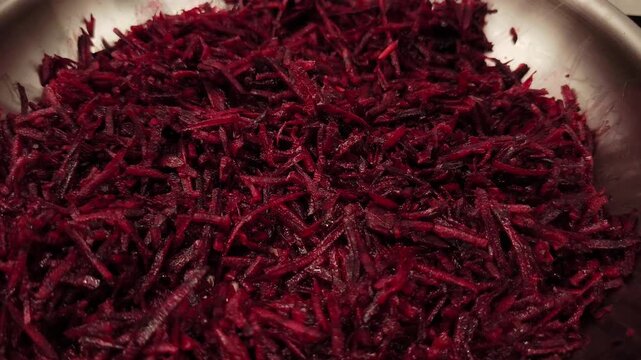Grated beetroot in bowl as ingredient for borscht soup