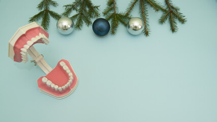 Christmas Medical Instruments, Tooth layout, with Christmas Tree and blue and silver balls on blue Background. New Year's photo of a medical hammer, orchidometer, tuning fork, stethoscope
