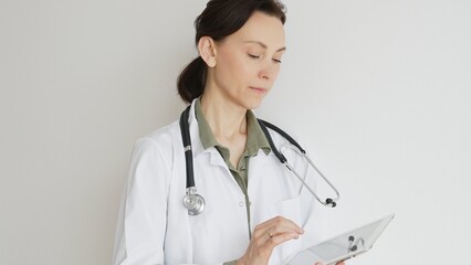 Confident doctor woman female medical professional wearing lab coat over green blouse and...