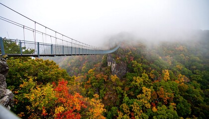 Misty mountain suspension bridge with colorful fall foliage