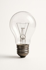Classic clear incandescent light bulb with visible filament on white background