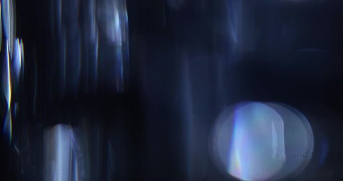 Abstract blurred light leaks on dark background with copy space. Studio anamorphic lens flare bokeh effect for title or logo display.