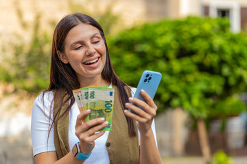 Happy young woman counting money euro cash, using smartphone calculator app, satisfied of income...