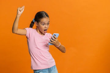 Young preteen child girl kid use mobile smartphone typing browsing say Wow yes found out great big...