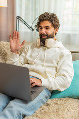 Happy young Hispanic man freelancer talking to web camera making an online video conference call...