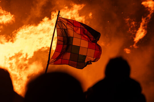 Whilala flag waving in the night in front of a bonfire.