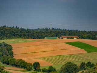 Strohrollen lagern neben einem landwirtschaftlichen Gebäude