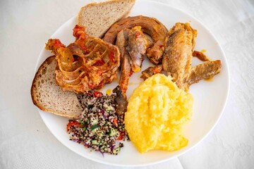 Traditional rustic Brazilian food, guinea fowl, Numida meleagris, with polenta, artisanal bread,...