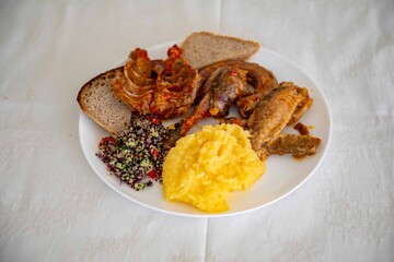 Traditional rustic Brazilian food, guinea fowl, Numida meleagris, with polenta, artisanal bread,...