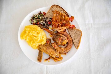 Traditional rustic Brazilian food, guinea fowl, Numida meleagris, with polenta, artisanal bread,...