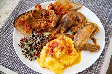 Traditional rustic Brazilian food, guinea fowl, Numida meleagris, with polenta, artisanal bread,...