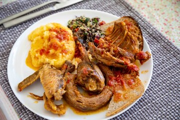 Traditional rustic Brazilian food, guinea fowl, Numida meleagris, with polenta, artisanal bread,...