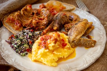 Traditional rustic Brazilian food, guinea fowl, Numida meleagris, with polenta, artisanal bread, and quinoa tabbouleh with vegetables. Real food
