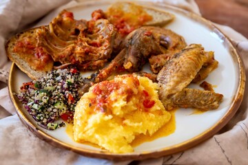Traditional rustic Brazilian food, guinea fowl, Numida meleagris, with polenta, artisanal bread, and quinoa tabbouleh with vegetables. Real food