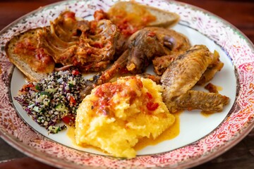 Traditional rustic Brazilian food, guinea fowl, Numida meleagris, with polenta, artisanal bread, and quinoa tabbouleh with vegetables. Real food