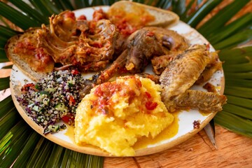 Traditional rustic Brazilian food, guinea fowl, Numida meleagris, with polenta, artisanal bread, and quinoa tabbouleh with vegetables. Real food