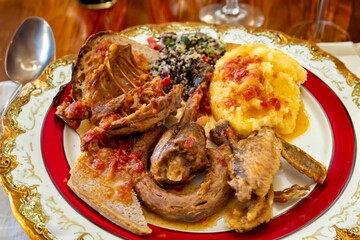 Traditional rustic Brazilian food, guinea fowl, Numida meleagris, with polenta, artisanal bread,...
