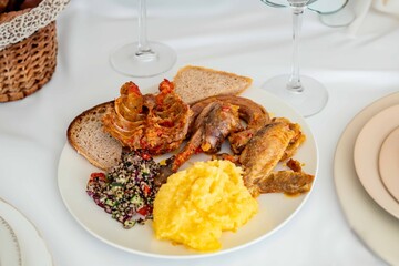 Traditional rustic Brazilian food, guinea fowl, Numida meleagris, with polenta, artisanal bread, and quinoa tabbouleh with vegetables. Real food