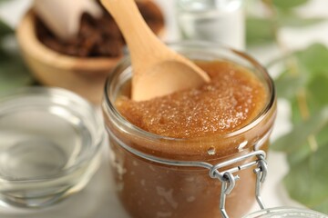 Natural body scrub and ingredients on white table, closeup