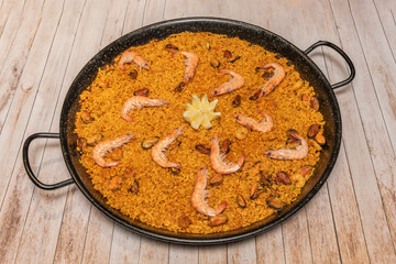 Seafood paella with peeled shrimp, clams, and mussels, where saffron gives the rice a golden yellow color.