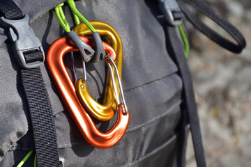 Yellow and orange carabiners on a backpack. Hiking backpack attachment.