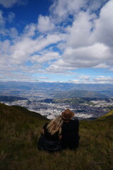 Fototapeta premium Couple Sitting On Top Of A Mountain