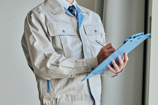 確認する作業服姿の男性