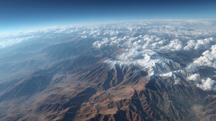 Aerial View of Majestic Mountain Range with Snow-Capped Peaks and Cloud Cover
