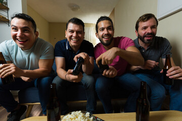 Friends playing video games and drinking beer at home