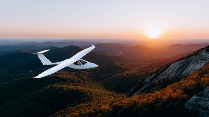 Fototapeta premium White glider flying over mountainous landscape at sunset autumn foliage visible