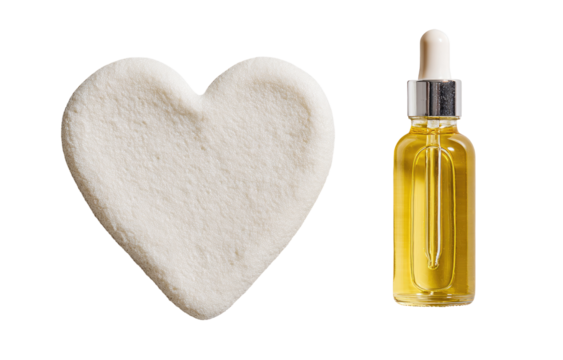 Heart-shaped, light-cream substance beside a golden dropper bottle
