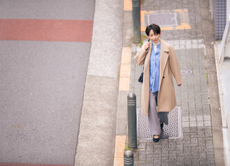 街中の歩道を歩く女性。