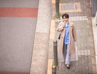 街中の歩道を歩く女性