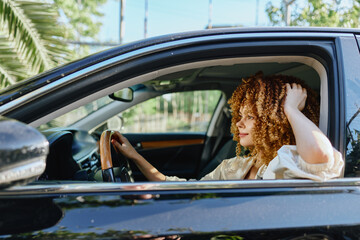 woman driving car with curly hair on sunny day, casual clothing, relaxed expression, modern vehicle...