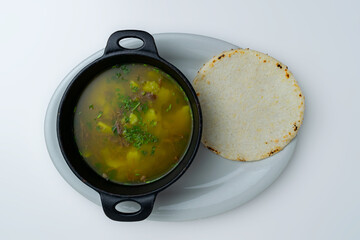 Traditional Colombian soup (Caldo), such as Caldo de Costilla or Ajiaco, a hearty homemade beef and...