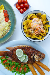 Top view flat lay of a Colombian food feast, a large spread of traditional and modern dishes including fried fish, creamy shrimp, and plantain chips, representing the rich gastronomy of Colombia