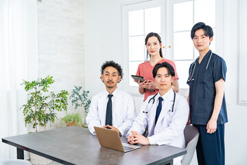 真剣な表情でカメラ目線の四人の医療従事者