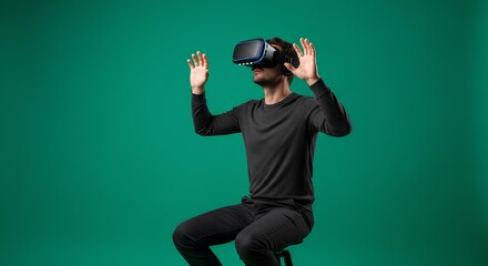 Man Immersed in Virtual Reality Sitting Against Green Background