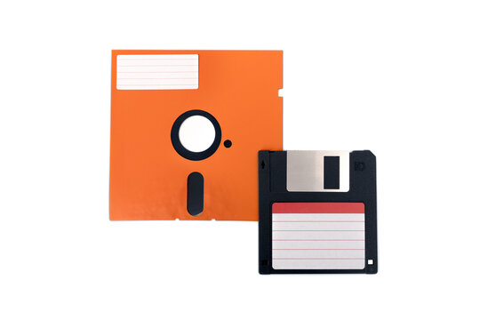 Retro vintage storage unit of computer. Old orange diskette or floppy disk 5.25" and black 3.5" with empty label sticker isolated on white background.