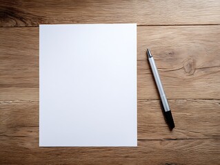 A blank white sheet of paper and a pen on a wooden surface. The paper is centered, and the pen is positioned to the right. The surface has a natural wood texture with visible grain patterns.