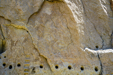 Los Alamos, NM, USA - May 18, 2025: Rock face of mountain displaying ancient petroglyphs and post holes made by indigenous people in Bandelier National Park