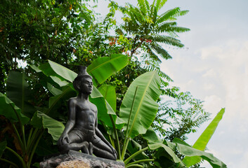 Statue of a hermit stretching under the shade of a tree inside Wat Pho or Pho Temple of Bangkok, Thailand. One of many statues of a hermit stretching in the area of the Wat Phra Chetuphon or Wat Pho